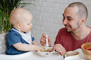 Un père qui donne à manger à son bébé